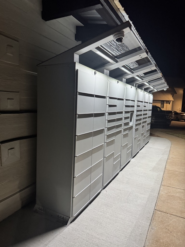 Luxer One® outdoor package locker kiosk installed under a lit canopy at a residential community
